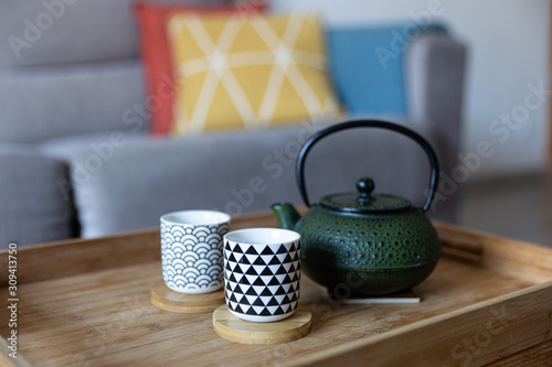 cast iron teapot and two cups, ready to serve