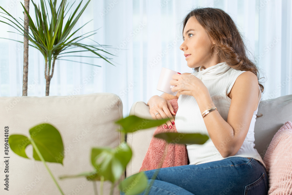 Woman thinking at home. Thoughtful woman looking away while drinking hot tea. Woman thinking at home. Thoughtful woman looking away while drinking hot tea.