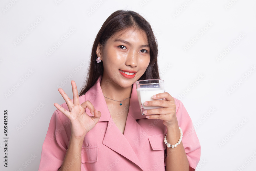 Healthy Asian woman drinking a glass of milk show OK sign. Healthy Asian woman drinking a glass of milk show OK sign.