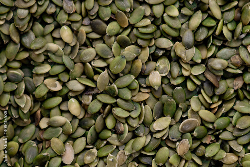 Peeled dry green pumpkin seeds in bulk. Top View.