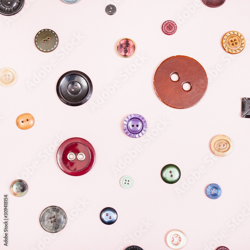 top view of various buttons placed on pink