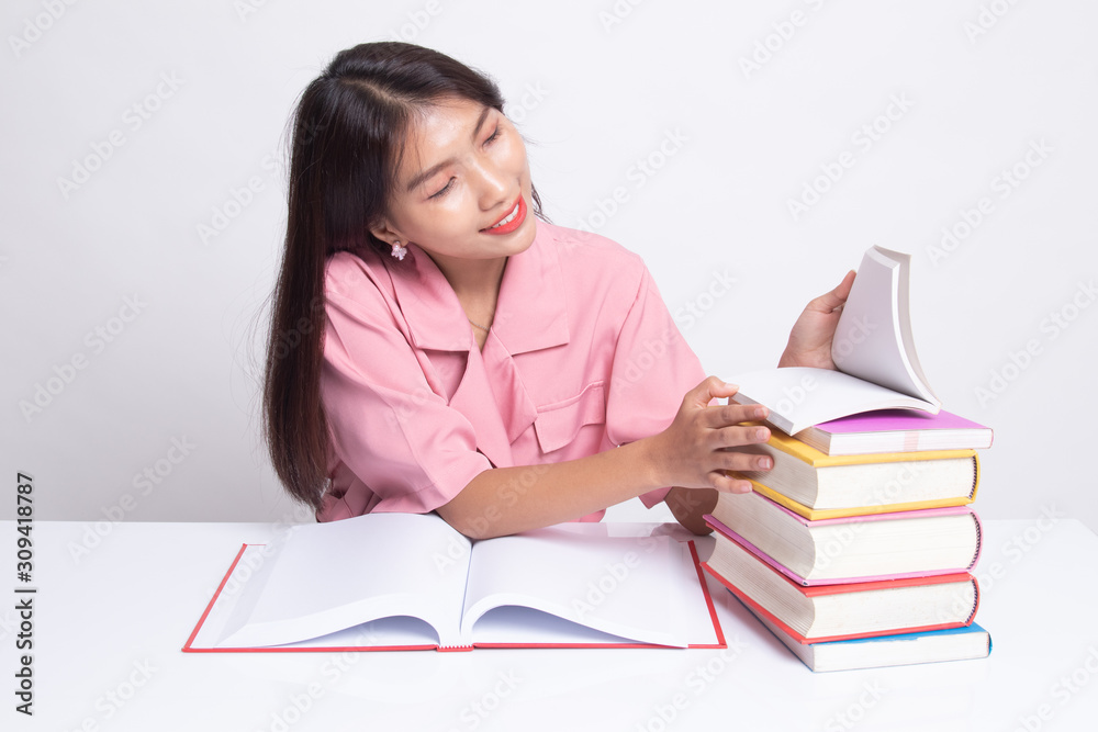 Young Asian woman read a book with books on table. Young Asian woman read a book with books on table.