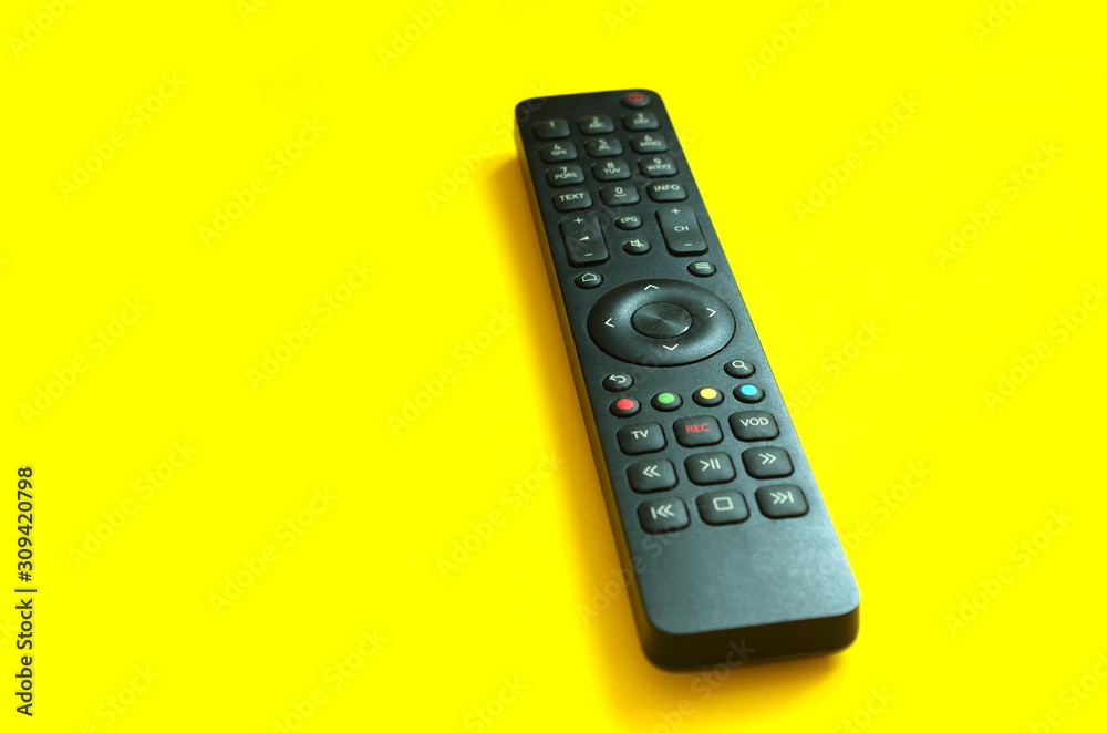 TV remote control on a yellow background. The concept of television, movies, TV shows, sports. Relax at home. TV remote control on a yellow background. The concept of television, movies, TV shows, sports. Relax at home.