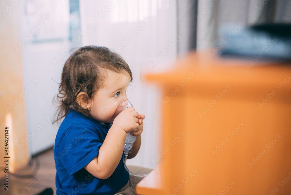 a little girl yourself holding the mask of the nebulizer, making inhalation a little girl yourself holding the mask of the nebulizer, making inhalation