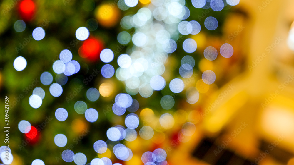 abstract blur image of christmas tree and bokeh light in department store