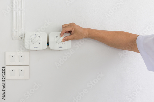 Tableau sur toile A man turning on a electric cycle fan dimmer switch.