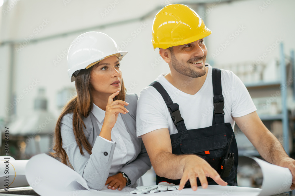 Close up of colleagues working on project in factory. 