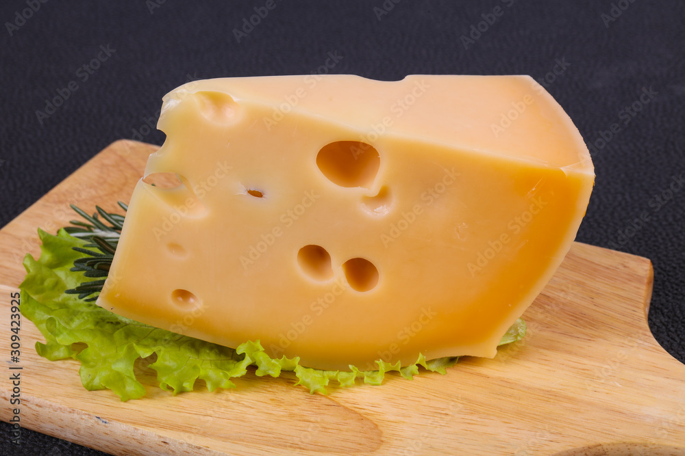 Maasdam cheese in the board served salad leaves Maasdam cheese in the board served salad leaves