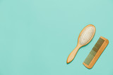 Two wooden hair combs on a mint background. View from above, flat lay.