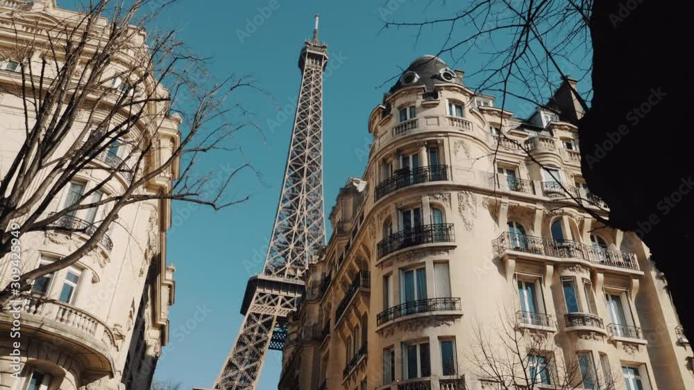 Cinematic camera moves left along trees, old apartment blocks revealing epic Eiffel Tower in sunny autumn morning Paris. Cinematic camera moves left along trees, old apartment blocks revealing epic Eiffel Tower in sunny autumn morning Paris.
