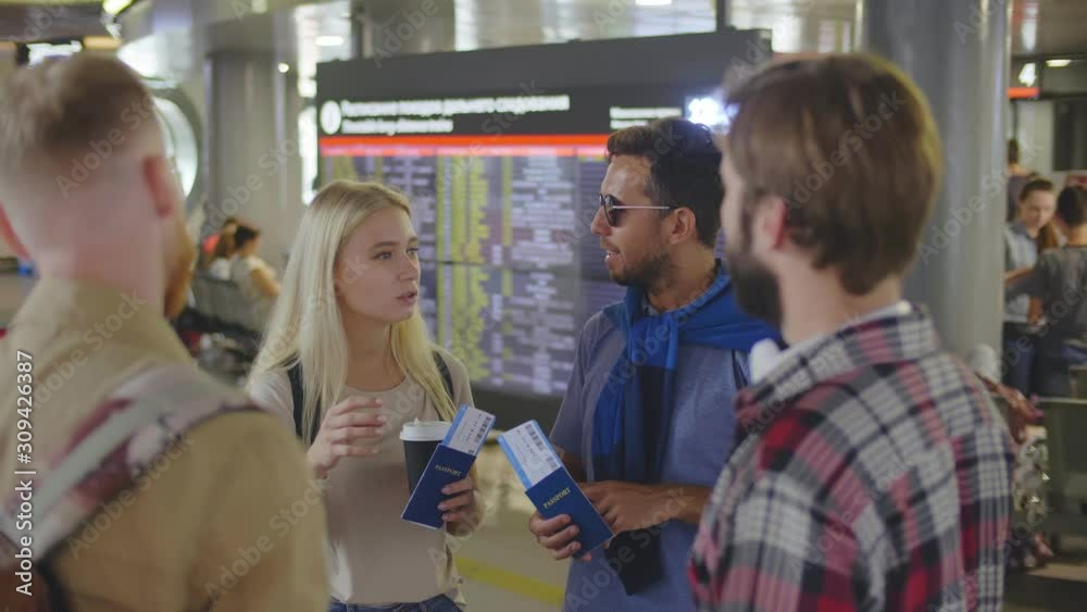 Tourists in airport hall talking while waiting for their flight Tourists in airport hall talking while waiting for their flight
