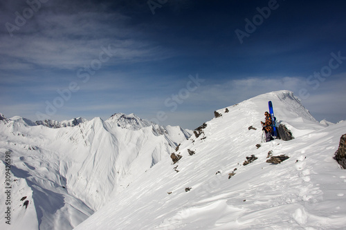 Skier with ski stands on a mountain top