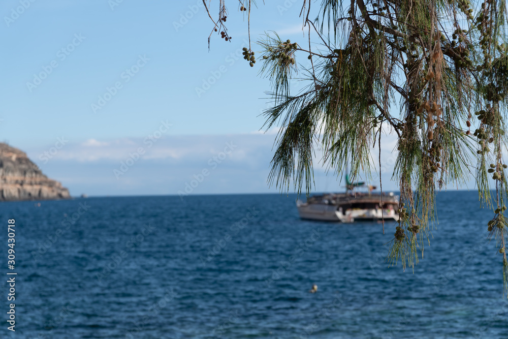 Selective focus, view of Puerto de Mogan coastline. Yacht in a background. Gran Canaria. Canary Islands, Spain Selective focus, view of Puerto de Mogan coastline. Yacht in a background. Gran Canaria. Canary Islands, Spain