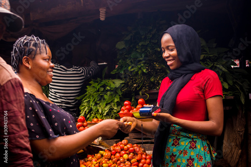 Photography close up of an african woman selling food stuff in a local african market holdin