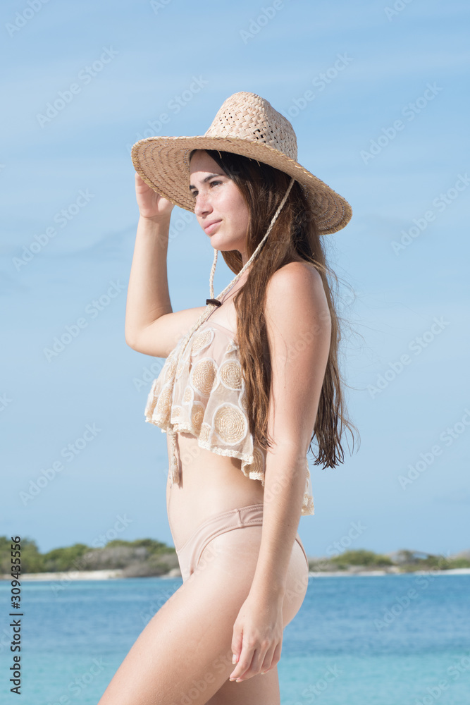 charming caucasian woman wearing bikini beach outfit posing sideways at caribbean beach 