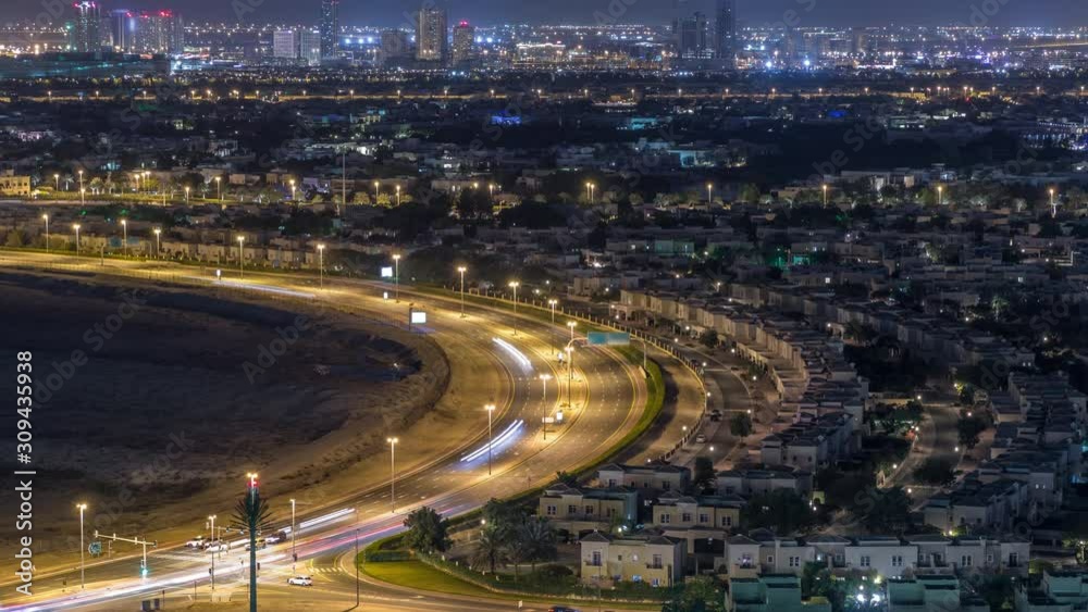 Aerial view to villas and houses with Golf course night timelapse. Traffic on intersection. Lakes with fountains Aerial view to villas and houses with Golf course night timelapse. Traffic on intersection. Lakes with fountains