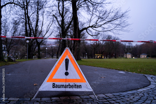 Schild Vorsicht Baumfällarbeiten an regnerischem Morgen