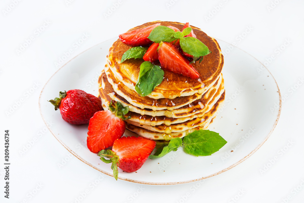American pancakes lined with strawberries and honey poured on a white background. Classic American Breakfast. American pancakes lined with strawberries and honey poured on a white background. Classic American Breakfast.
