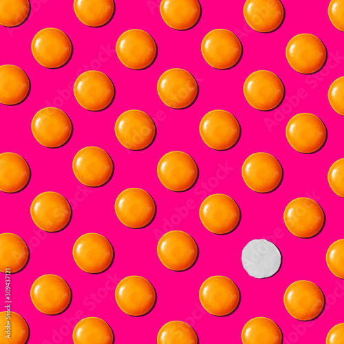Creative pattern with egg's yolks and one eggwhite on a pink background.