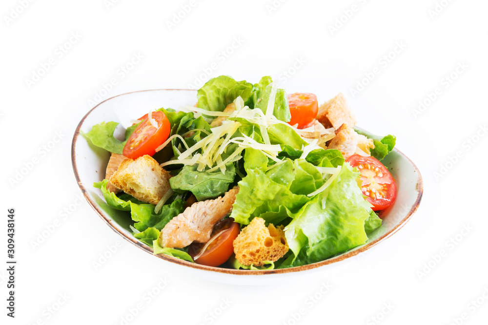 Caesar salad with chicken breast, tomatoes and wheat croutons in a plate on a white background. Horizontal photo. Caesar salad with chicken breast, tomatoes and wheat croutons in a plate on a white background. Horizontal photo.