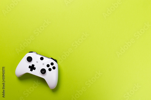 White joystick gamepad, game console ongreen background. Computer gaming technology play competition videogame control confrontation concept. Cyberspace symbol photo