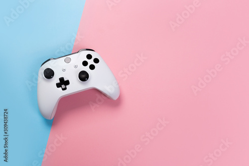 White joystick gamepad, game console on pink and blue background. Computer gaming technology play competition videogame control confrontation concept. Cyberspace symbol