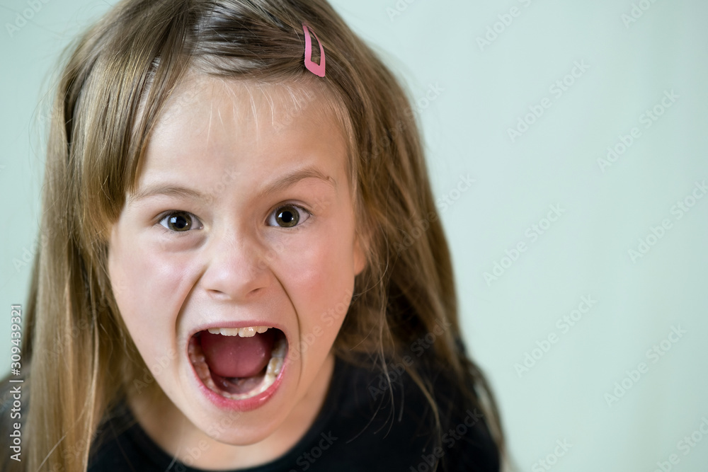 Close up portrait of angry shouting child girl looking aggressively in camera. Close up portrait of angry shouting child girl looking aggressively in camera.