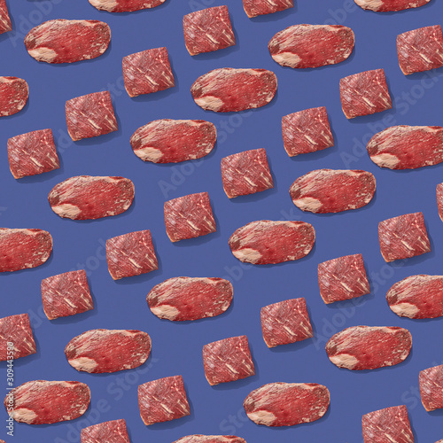 Fresh raw beef meat in a creative pattern on a violet background