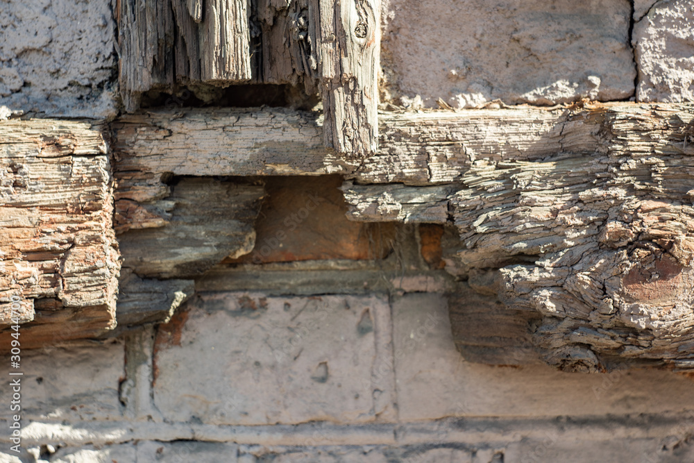 Antique stone wall surface with decayed wooden part is close Antique stone wall surface with decayed wooden part is close