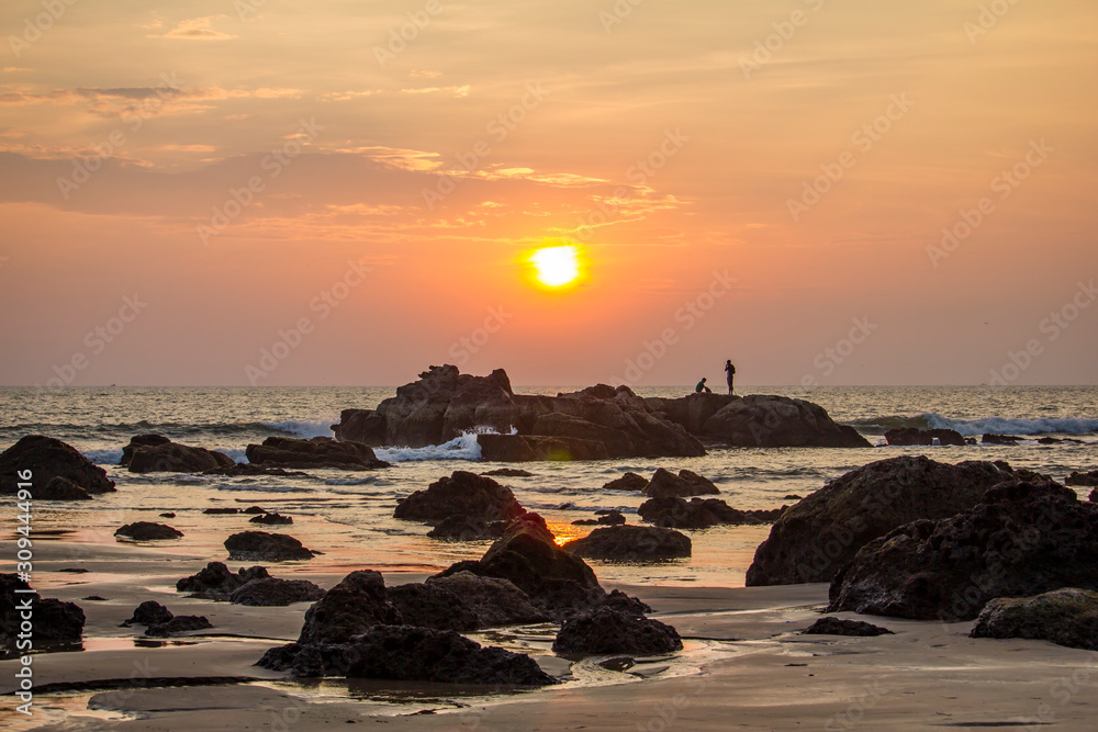 Fishermen on the rocks during sunset