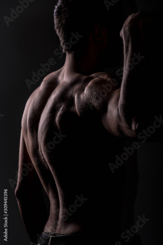 Strong athletic man on black background, Fitness shaped muscle man posing  © John Ilich