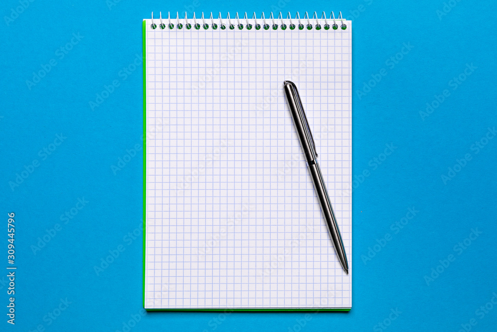 school notebook on a blue background, spiral notepad on a table school notebook on a blue background, spiral notepad on a table