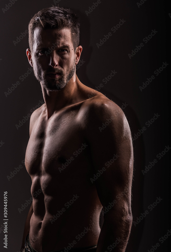 Strong athletic man on black background, Fitness shaped muscle man posing