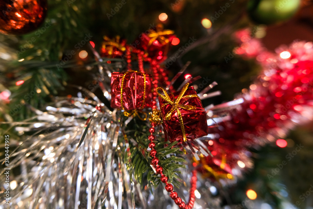 Selective focus and blurred background. Christmas tree with a garland and gifts is a symbol of a Happy New Year.