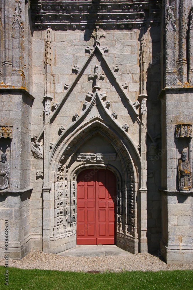 Entrance with gothic tracery and wooden door at Saint Tugen chapel in Primelin village, France