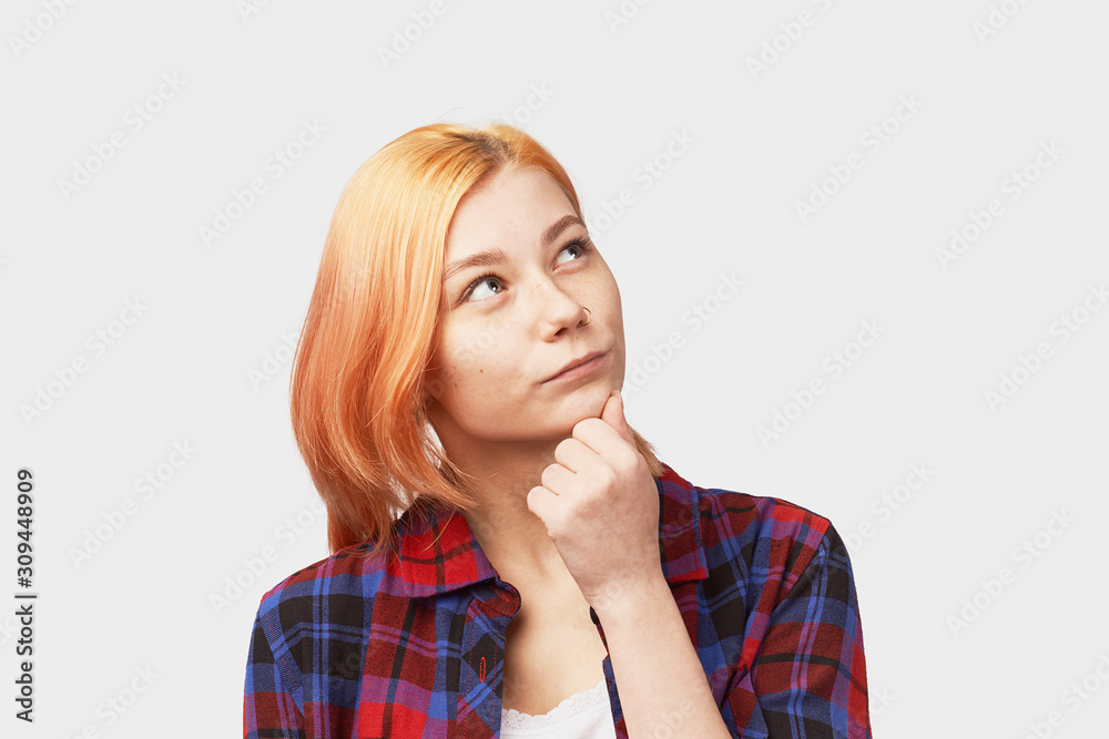 Portrait of handsome girl having concentrated thoughtful expression, frowning, keeping her fingers on chin, as if trying to remember something. Young beautiful girl isolated on white background Portrait of handsome girl having concentrated thoughtful expression, frowning, keeping her fingers on chin, as if trying to remember something. Young beautiful girl isolated on white background