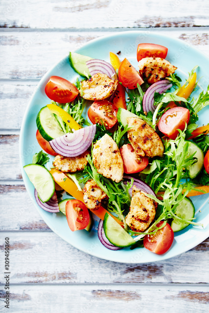 Healthy Salad with Chicken Briest, Cherry Tomatoes, Cucumber, Rocket and fresh Basil. Bright wooden background. Top view. Healthy Salad with Chicken Briest, Cherry Tomatoes, Cucumber, Rocket and fresh Basil. Bright wooden background. Top view.
