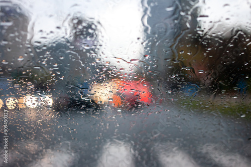 wet windshield water flows blurred car lights