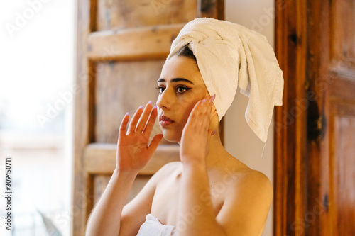 Young sensual woman in towel near window photo