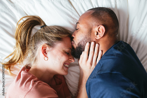 Multiethnic lovers on bedroom.