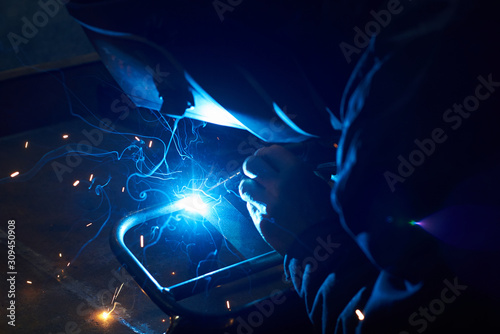 A man in a protective mask carries out welding work.