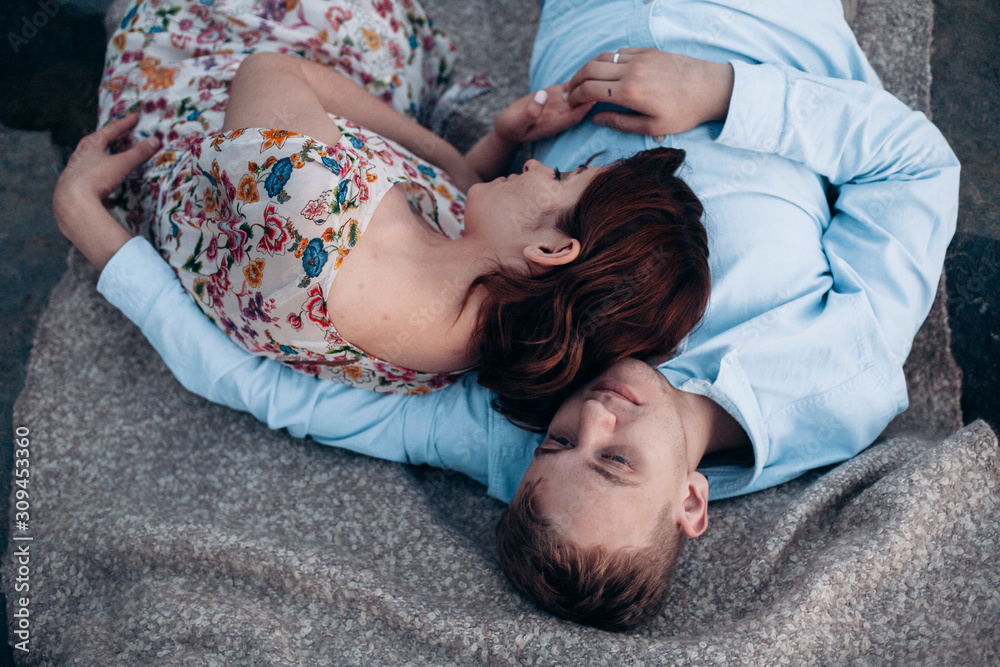 couple in love lying on the blanket embracing couple in love lying on the blanket embracing