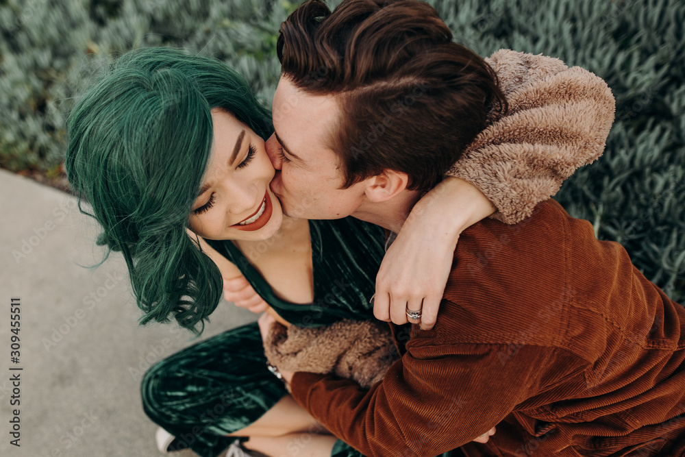 Young playful cute couple hugging and laughing and kissing Young playful cute couple hugging and laughing and kissing