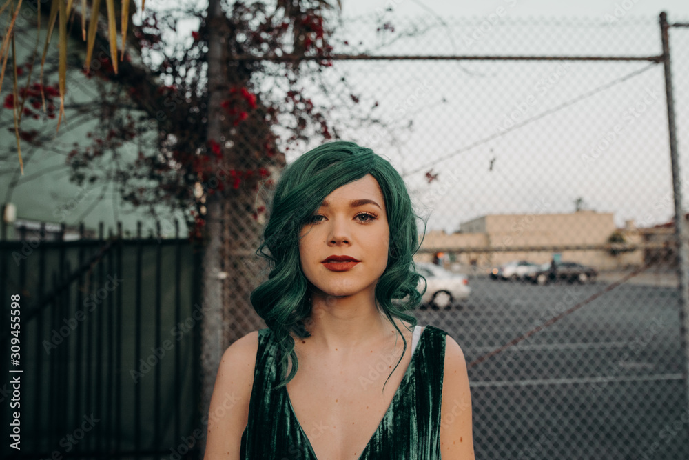 Young glamorous woman with green hair and red lipstick looking at the camera with a blank face Young glamorous woman with green hair and red lipstick looking at the camera with a blank face