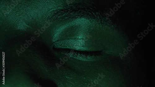 scared young black african man opening his eyes in the dark