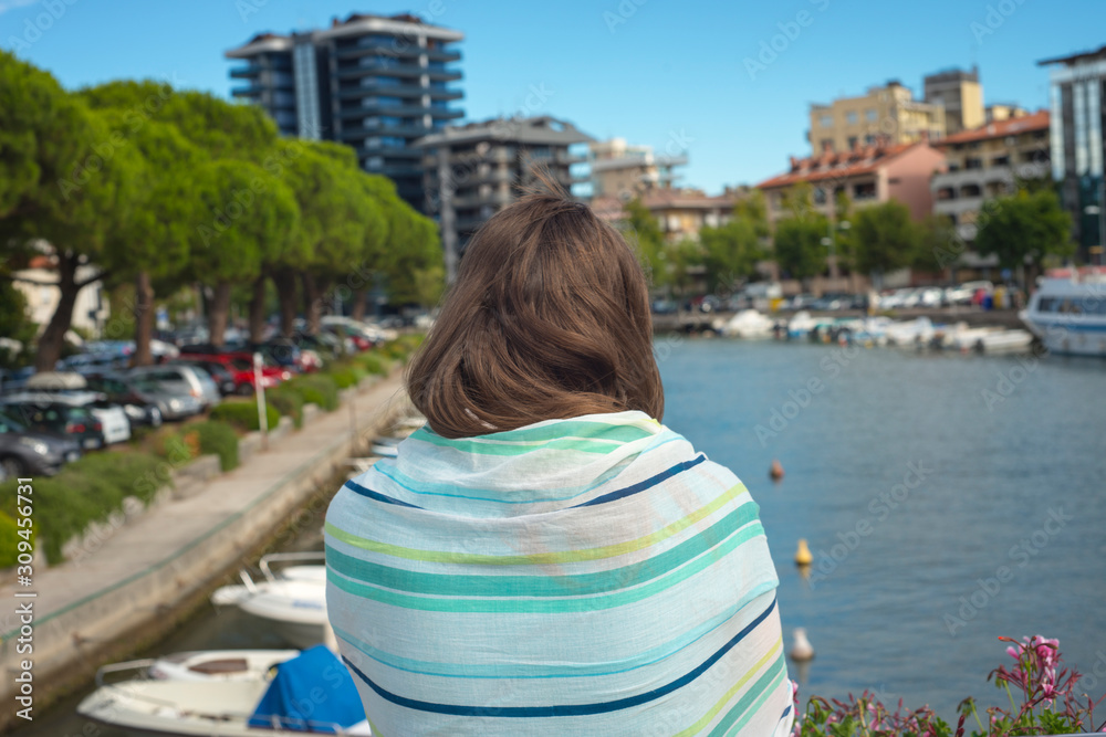 Woman enjoying the view in the resort harbor of a modern village sea port