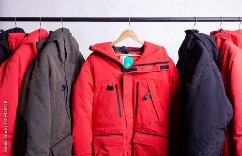 family concept or showroom of down jacket winter parka hanging on a hanger in the wardrobe photo