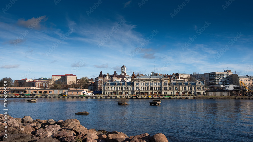 Panorama of the embankment with ancient beautiful buildings of the city of the middle-century city of Vyborg in Russia on an autumn sunny day