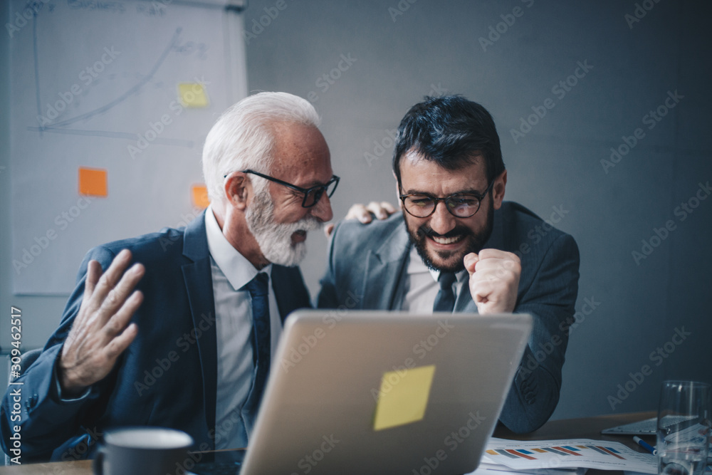 Two businessmen at the office realizing the results are more than satisfying.