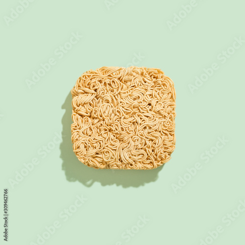 Raw instant noodle isolated on light green background.